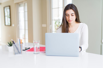 Young beautiful woman concentrated working using computer laptop