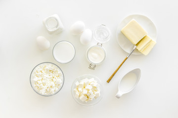 Fresh dairy products for breakfast with milk, cottage, eggs, butter, yougurt on white background top view