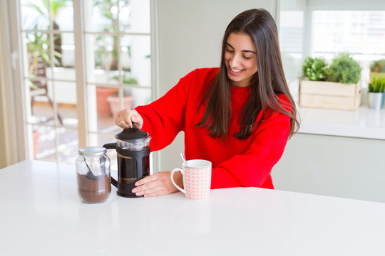 Young beautiful woman making morning coffee smiling, preparing a cup of latte for breakfast