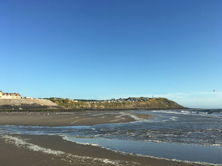 beach with mountains and houses in the distance