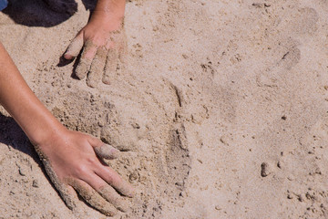 childish hands playing in the sand