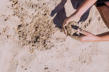 childish hands playing in the sand