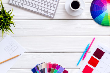 Designer office desk with tools, pallet, coffee, keyboard and pens on white wooden background top...