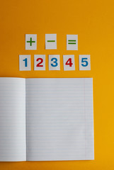 Notebook, numbers on a yellow background. Accessories for study. Mathematics, geometry, algebra.