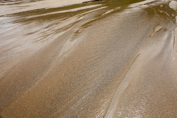Feathery water sand pattern on a beach low tide