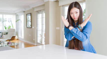 Fototapeta na wymiar Young beautiful asian woman with long hair wearing denim jacket Rejection expression crossing arms doing negative sign, angry face