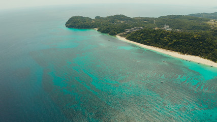 Naklejka na ściany i meble Sandy beach and turquoise water in the tropical resort of Boracay, Puka shell beach, Philippines aerial view. White beach with tourists. Summer and travel vacation concept.
