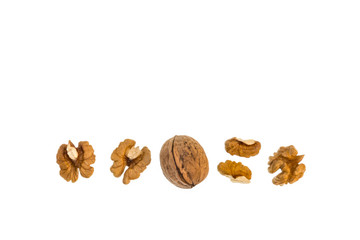 whole and halved organic walnut kernels isolated on white background with copy space above