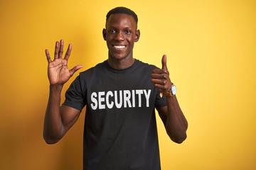 African american safeguard man wearing security uniform over isolated yellow background showing and pointing up with fingers number six while smiling confident and happy.