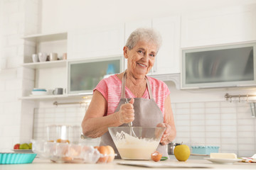 Portrait of beautiful grandmother cooking in kitchen