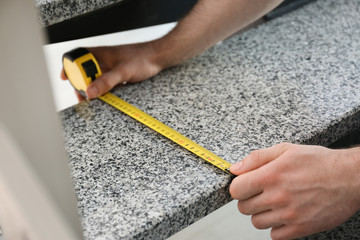 Man measuring stone step, closeup. Construction tool