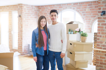 Fototapeta na wymiar Beautiful young asian couple looking happy and smiling excited moving to a new home