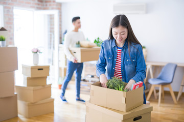 Beautiful young asian couple looking happy and smiling excited moving to a new home