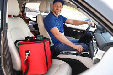 Male courier with thermo bag in car. Food delivery service
