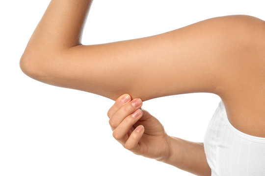 Young woman drawing attention to arm on white background, closeup. Plastic surgery concept