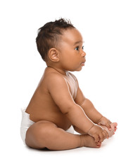 Adorable African-American baby in diaper on white background