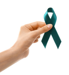 Woman holding teal awareness ribbon against white background, closeup