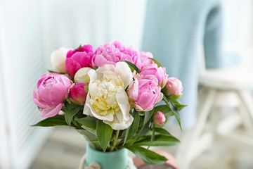 Bouquet of beautiful peonies in room, space for text
