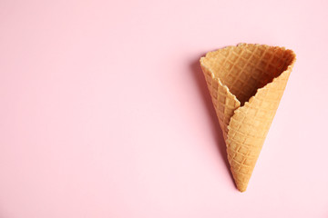 Empty wafer ice cream cone on pink background, top view. Space for text
