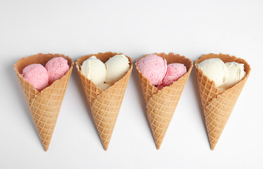 Delicious ice creams in wafer cones on white background, top view
