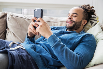 Handsome man with dreadlocks looking at his phone
