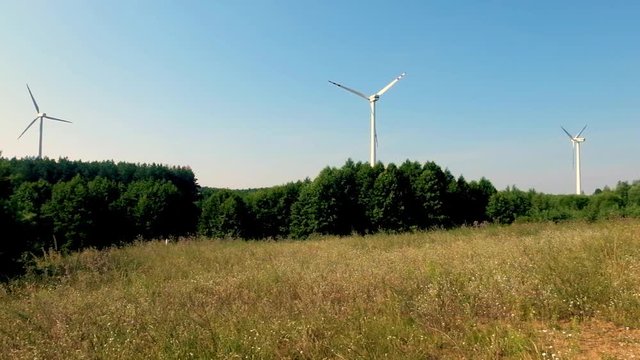 Slowly rotating blades of a windmill propeller. Wind power generation. Pure green energy.