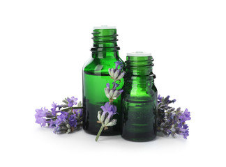 Bottles with natural lavender oil and flowers on white background