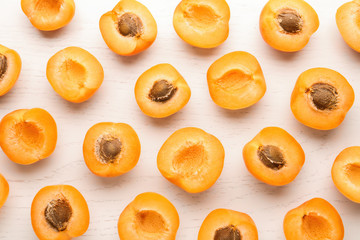 Flat lay composition with delicious ripe apricots on white wooden background