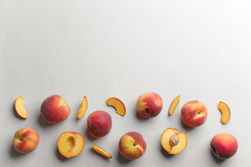 Flat lay composition with fresh peaches on grey background. Space for text