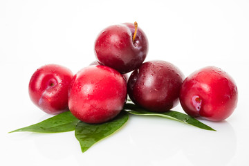 plums with plum leaves on a white background