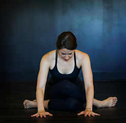 Fototapeta na wymiar Young white woman does yoga poses in a studio. 