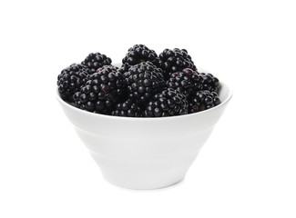Ceramic bowl of tasty ripe blackberries on white background