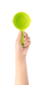 hand holding green plastic scoop isolated on white background