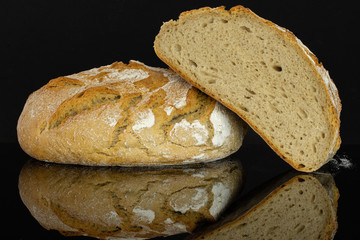 Group of one whole one half of fresh baked rye wheat bread cross section isolated on black glass