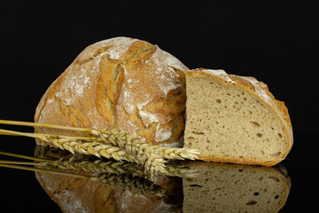 Group of one half one slice of fresh baked rye wheat bread with golden wheat ears isolated on black glass