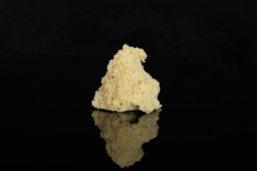 One pinched off piece of fresh baked rye wheat bread isolated on black glass