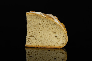 One slice of fresh baked rye wheat bread isolated on black glass