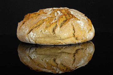 One whole fresh baked rye wheat bread loaf isolated on black glass