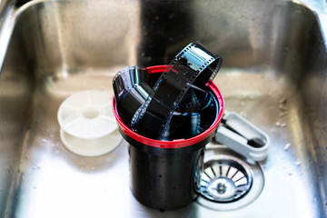 Film developing tank with 135 photographic film in a tank after developed close up.