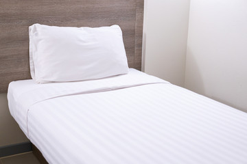 White single bed and pillow in the bed room close up.