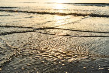 Beautiful texture of sea water surface at the beach during the sunrise.