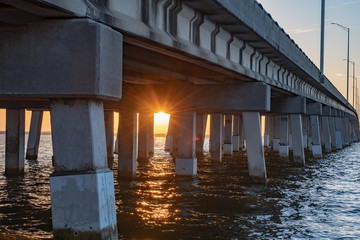 Sunrise under a bridge over the water