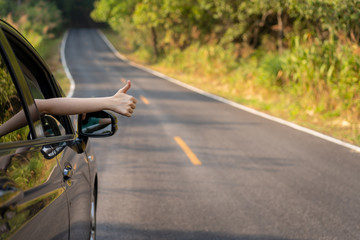Woman in the car showing her thumb up.  Safe driving concept.  Transportation and driving concept and background.
