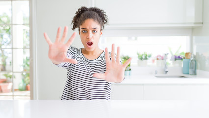 Beautiful african american woman with afro hair wearing casual striped sweater doing stop gesture with hands palms, angry and frustration expression