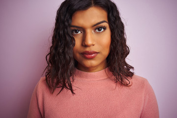 Young beautiful transsexual transgender woman standing over isolated pink background with a confident expression on smart face thinking serious