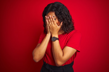 Beautiful transsexual transgender woman wearing t-shirt over isolated red background with sad expression covering face with hands while crying. Depression concept.