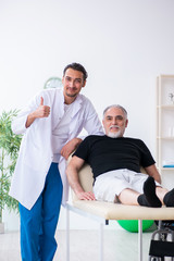 Fototapeta premium Old injured man visiting young doctor