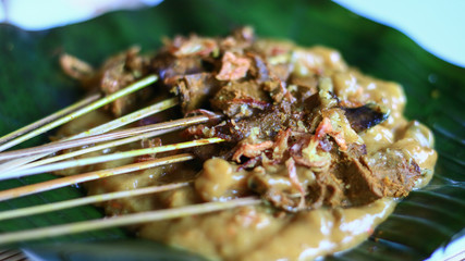 Sate Padang or Padang Satay on banana leaf. Sate Padang is specialty Beef satay from West Sumatra, Indonesia served in aromatic curry-like thick sauce.