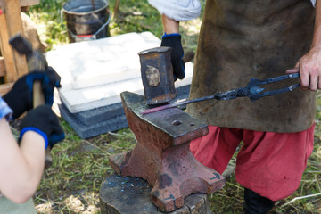Forge. The blacksmith processes the heated metal with a sledgehammer on the anvil. Manual work of a...