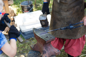 Forge. The blacksmith processes the heated metal with a sledgehammer on the anvil. Manual work of a...